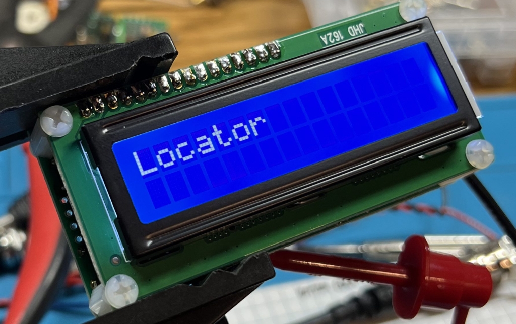U3S in a clamp fixture, with the word "Locator" displayed on the LCD screen.